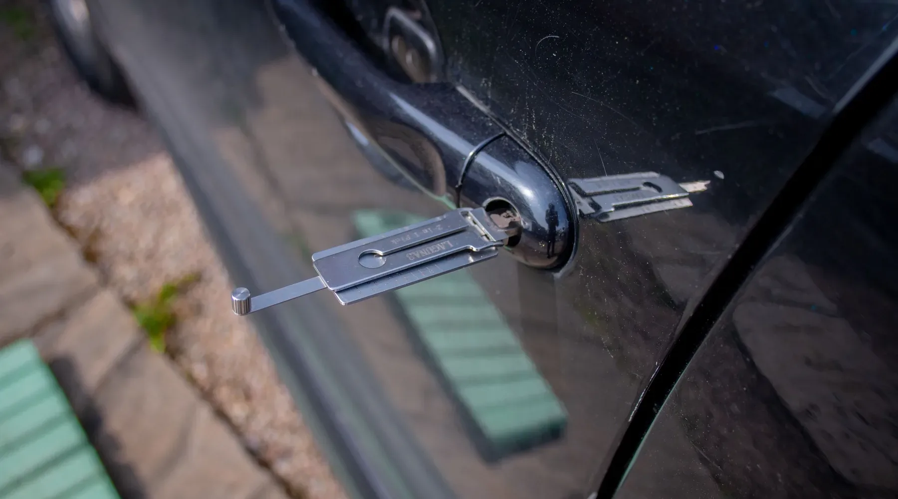 Locksmith tool working at a vehicle door lock